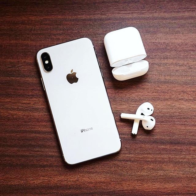 Apple iPhone and AirPods on Wooden Table – Wireless Tech Setup
